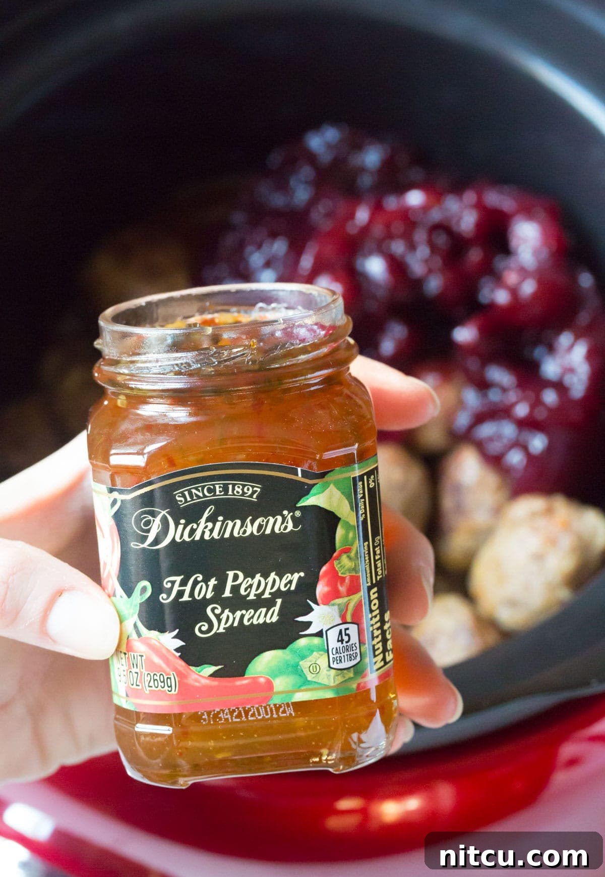 Adding Dickinson's jalapeno jelly to the slow cooker for the cocktail meatballs