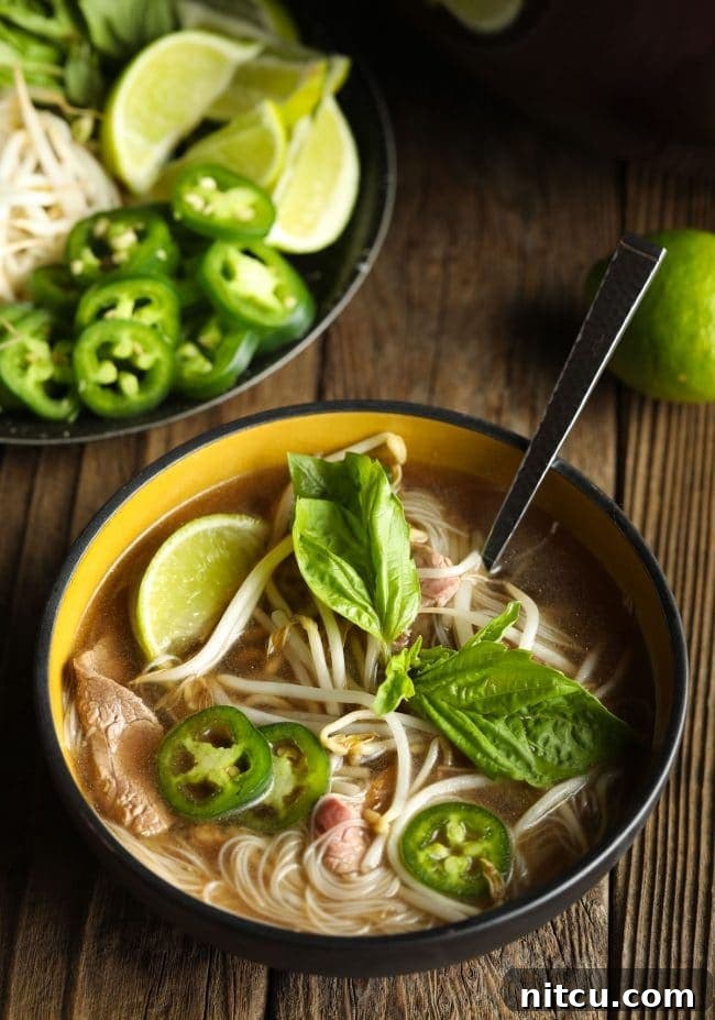 Adding a medley of fresh garnishes like basil, jalapeños, and lime to a steaming bowl of homemade pho soup for a burst of flavor.