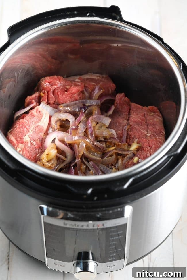 Sautéed onions and garlic with beef in the Instant Pot before pressure cooking.