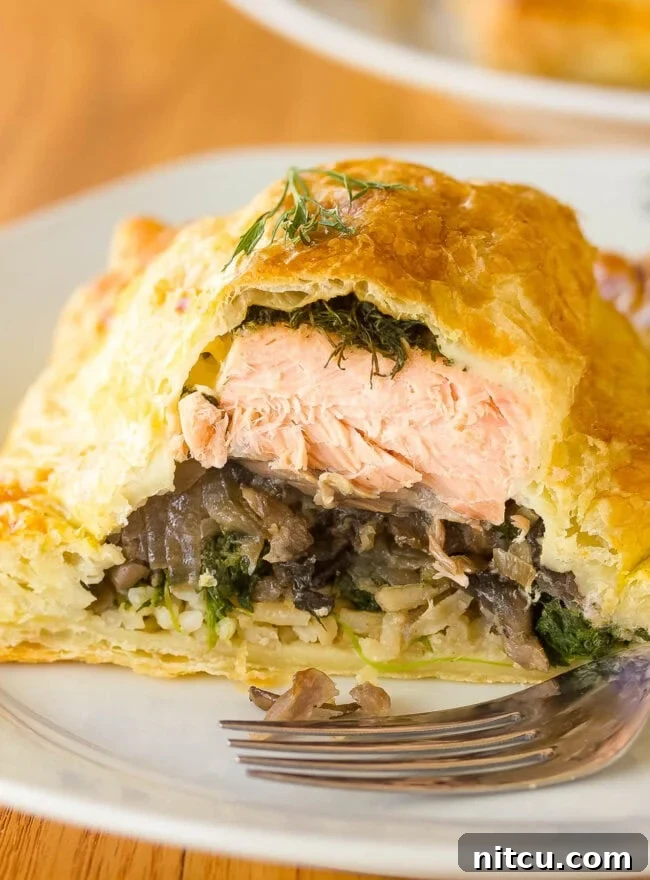 Exquisite Salmon Coulibiac, also known as Salmon Wellington, sliced open to reveal its beautifully crafted layers of salmon, rice, and mushrooms.