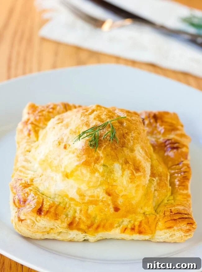 Individual Coulibiac of Salmon, perfectly wrapped in puff pastry and baked to a golden crisp, ready to be served.