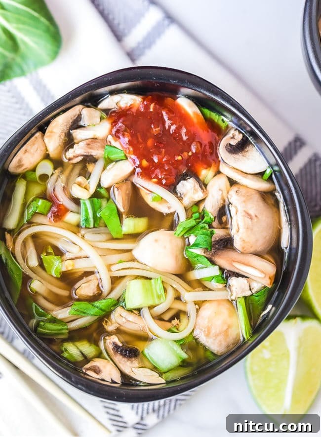 Overhead shot of hot pot bowl with spicy hot sauce on top.