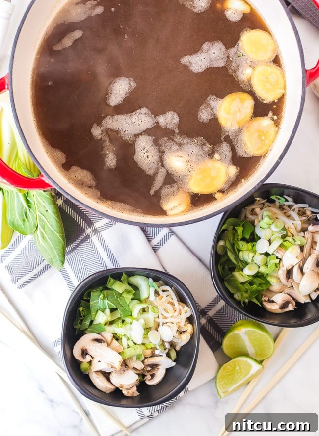 Chicken broth simmering with ginger, sauces and garlic.
