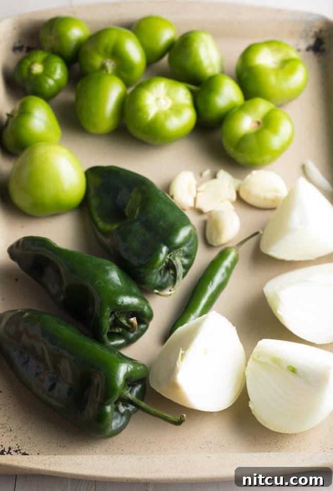Assorted vegetables for Enchiladas Suiza on baking sheet before roasting.