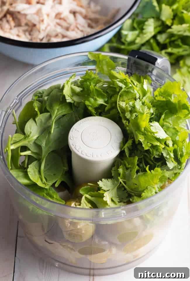 Blender jar with salsa verde ingredients before blending.