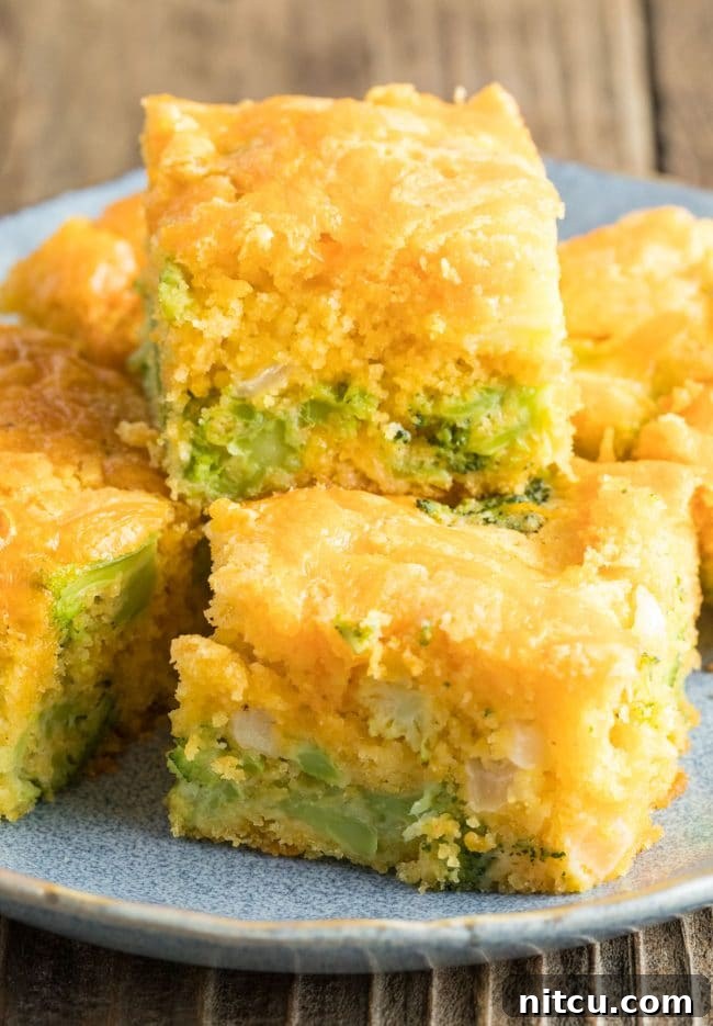 Close-up of Jiffy Broccoli Cornbread on a plate, showing embedded broccoli pieces and melted cheese