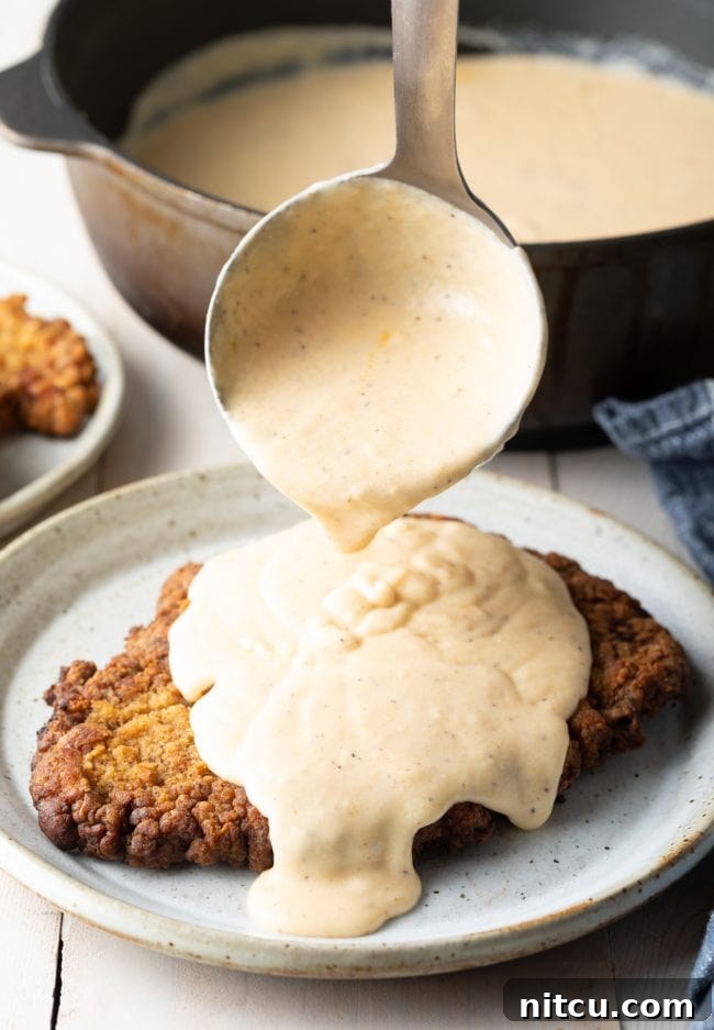 Fried Steak Recipe: A plate of freshly fried steaks, golden and crispy, highlighting the inviting texture of the breading before being drenched in gravy.