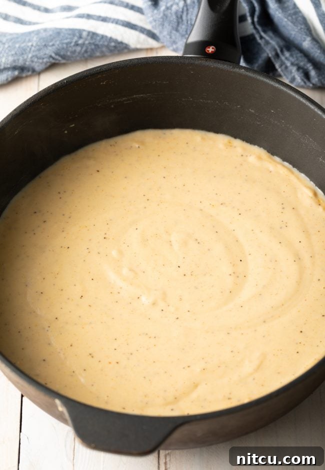 Country Gravy Recipe: A close-up of a rich, creamy white country gravy, showing its smooth texture and hints of black pepper.