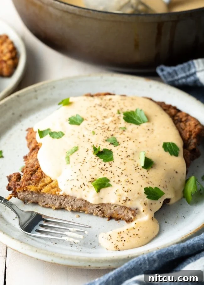 How to make chicken fried steak: A final, mouth-watering shot of a chicken fried steak dinner, complete with sides, emphasizing the comfort and satisfaction of the meal.