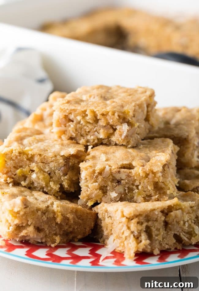 Hummingbird blondies cut into bars and served on a plate, showcasing their moist texture and flavorful mix-ins.