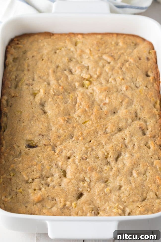 Freshly baked hummingbird blondies cooling in a baking dish, with a golden-brown top.
