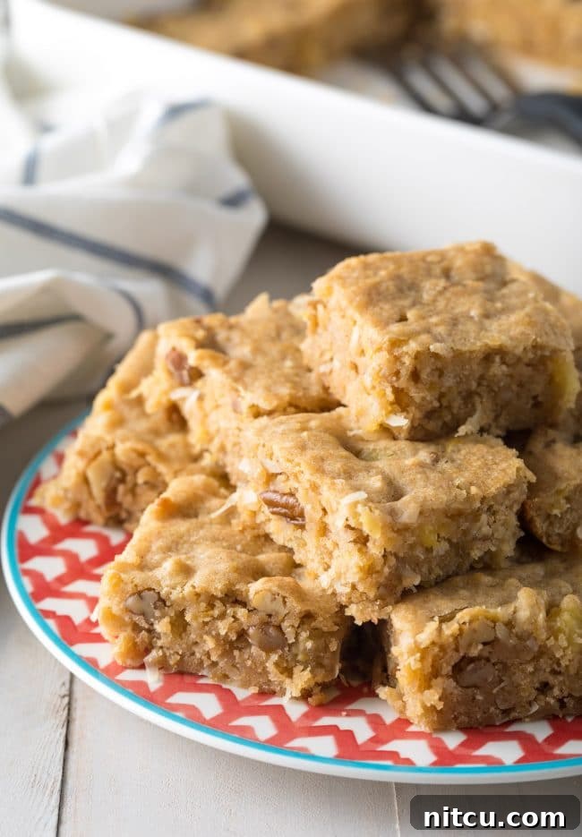 Delicious hummingbird cookie bars stacked on top of each other on a plate, ready to be enjoyed.