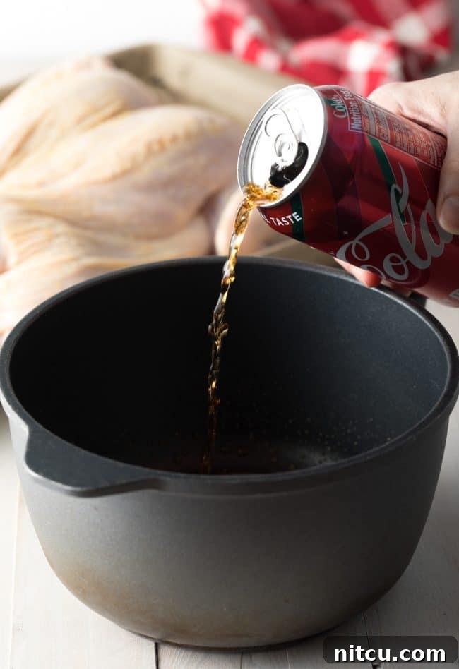Pouring Coca-Cola into a pan to prepare the glaze.