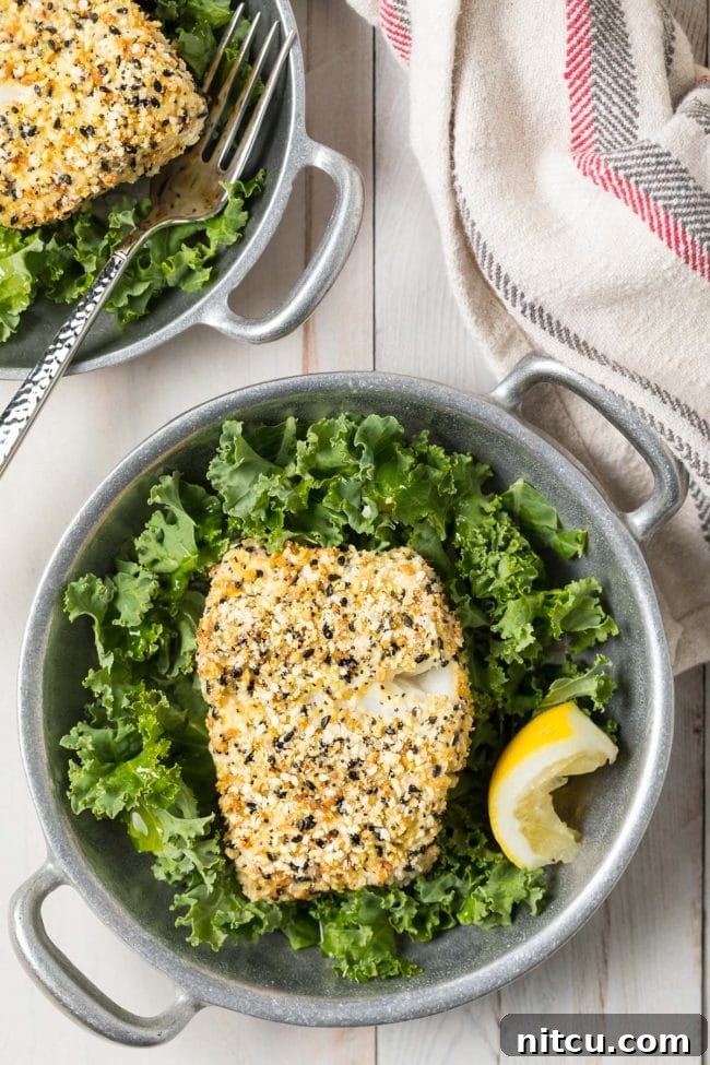 Crispy everything bagel seasoned cod served in a bowl with lettuce and lemon. 