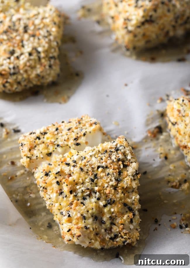 Everything bagel seasoned cod on a baking sheet after being baked. 