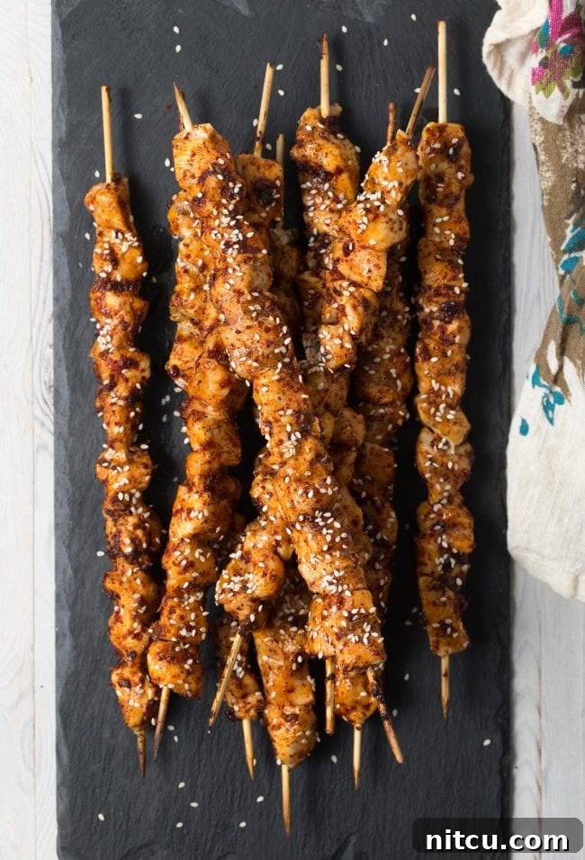 Delicious Low Carb Korean Chicken Skewers on a grill, garnished with sesame seeds.