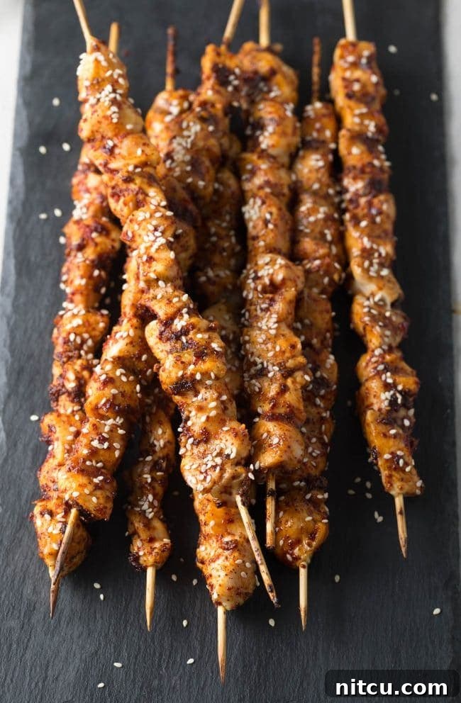 Close-up of grilled Korean chicken skewers, glistening with spicy glaze.
