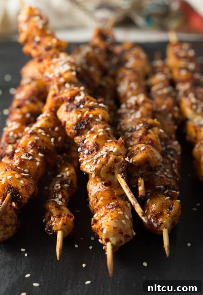 Close-up shot of grilled Korean chicken skewers on a serving board.