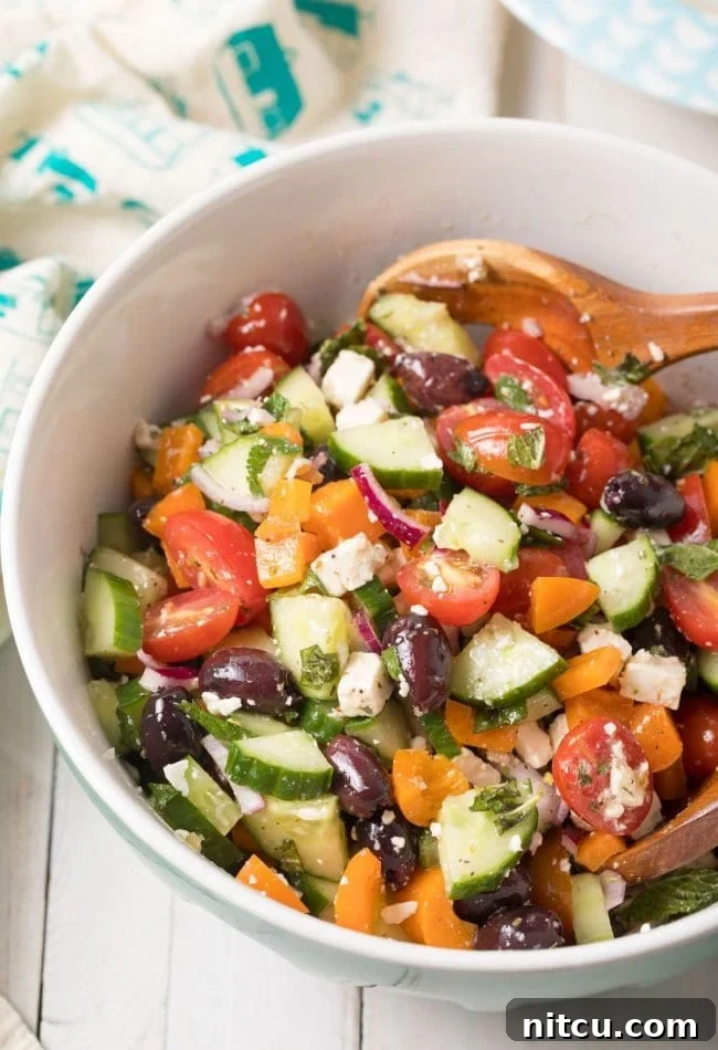 Horiatiki (Greek Village Salad) Recipe with fresh tomatoes, cucumbers, feta, and olives, garnished with herbs. #greek #salad #glutenfree #lowcarb #keto #vegetarian