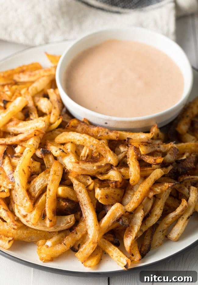 Delicious Baked Turnip Fries on a plate with dipping sauce, ready to be enjoyed.