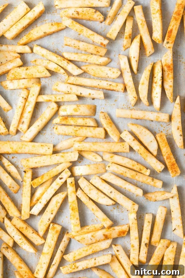 Turnip fries cooking in an air fryer basket, highlighting an alternative, healthier cooking method.