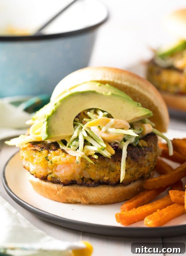 Shrimp Burger with lots of toppings, including avocado and mango slaw