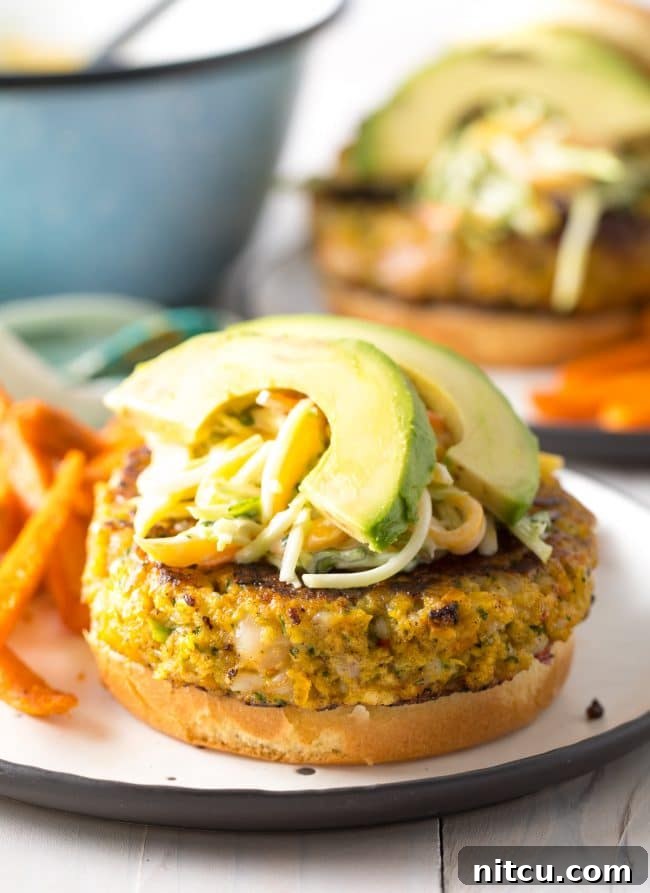 Close-up of a Caribbean Shrimp Burger with fresh toppings and mango slaw