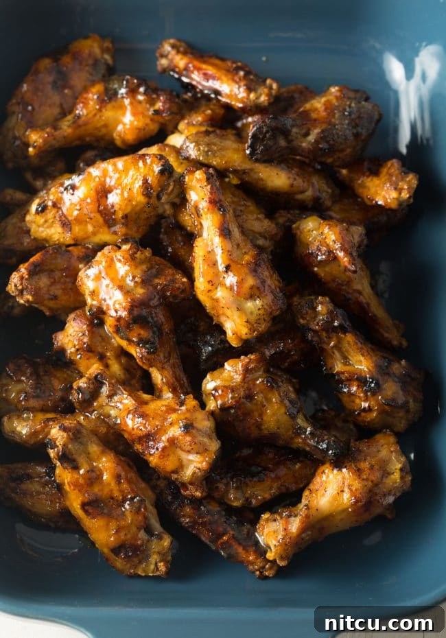 Blue baking dish loaded with grilled habanero peach chicken wings.