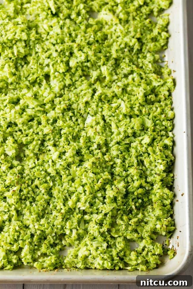 Sheet pan filled with freshly roasted riced broccoli, a delicious and healthy rice substitute