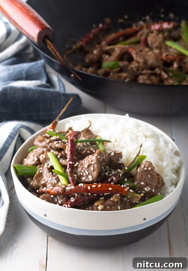 Final Szechuan Beef recipe in a bowl served with some white rice