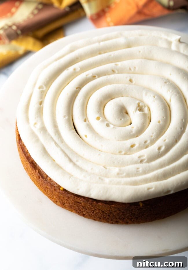 First layer of cake topped off with swirl of frosting. 