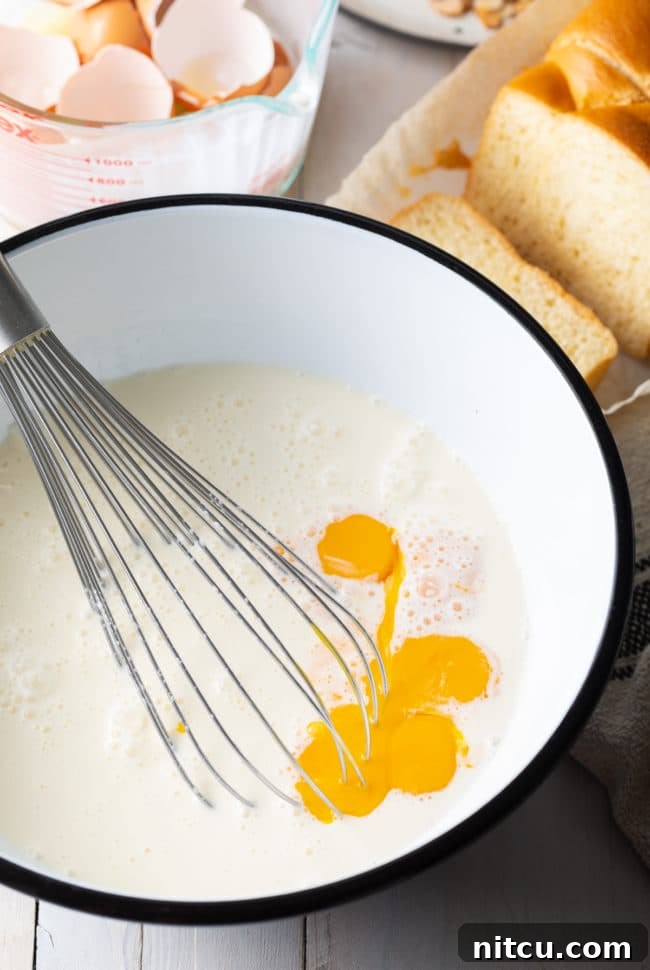 Egg mixture in a white bowl with a whisk.