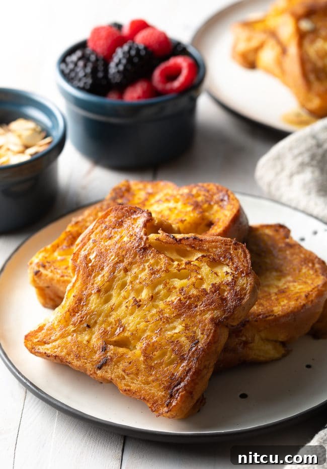 Slices of pain perdu on a white plate.
