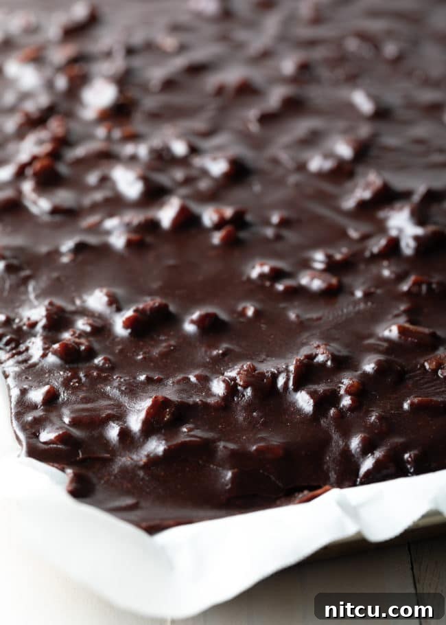 Close up view of Texas Sheet Cake in a pan lined with parchment paper.