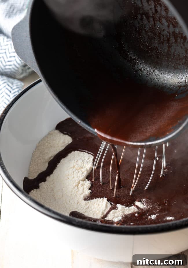 Pouring cocoa mixture into the flour mixture.