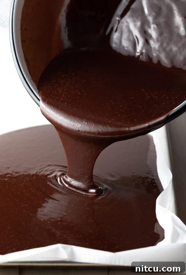 Pouring sheet cake batter into the sheet pan.