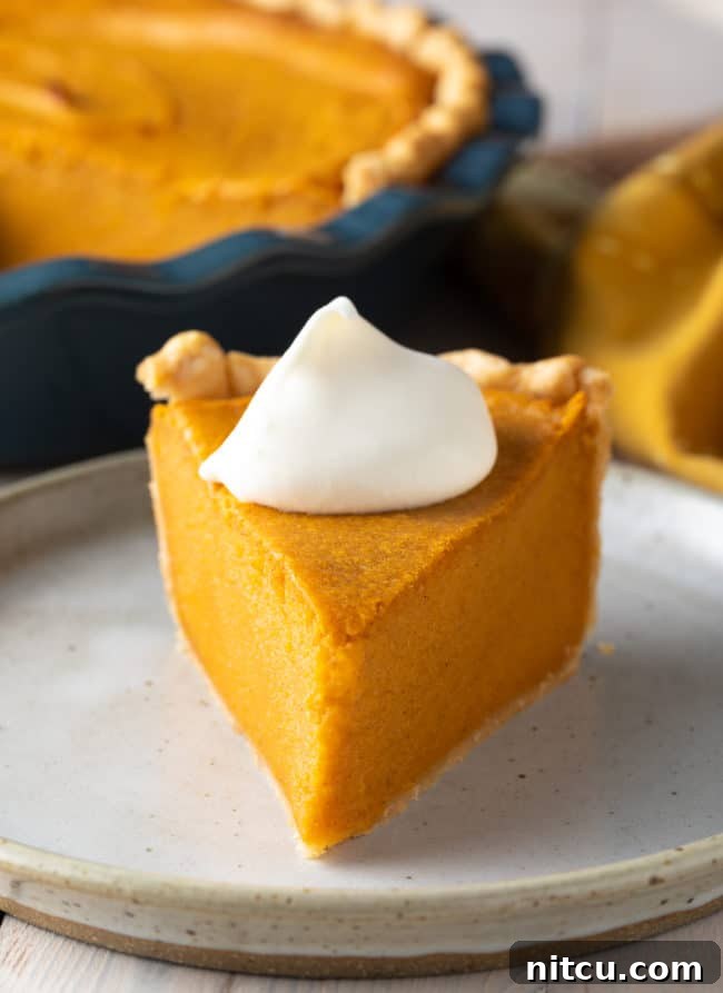 A slice of old-fashioned Southern Sweet Potato Pie on a white plate, showcasing its creamy texture and golden crust, ready to be enjoyed.