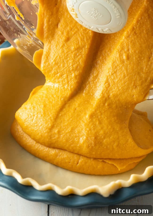 A beautifully baked Thanksgiving sweet potato pie, ready for serving. Its golden-brown crust and smooth filling evoke feelings of warmth and holiday festivity.