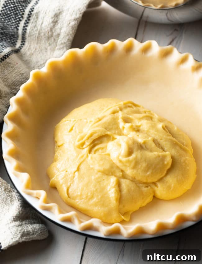 A bowl of the creamy Tres Leches mixture, ready to be poured over the baked sponge cake in the pie crust.