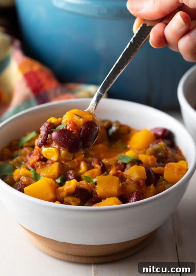 A spoonful of slow cooker vegetarian chili, showing its thick texture and wholesome ingredients.