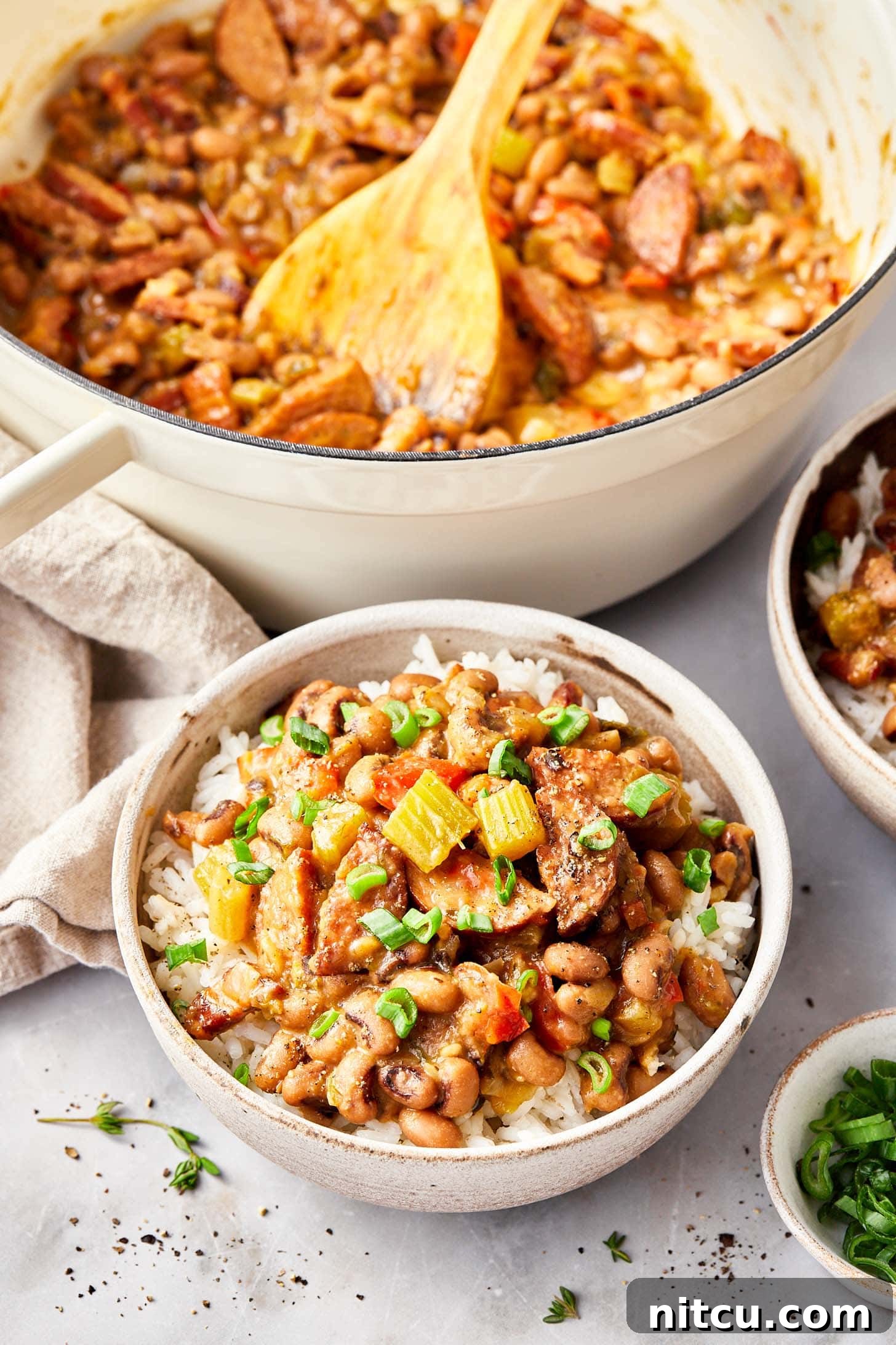 Overhead shot of a pot brimming with Hoppin' John next to a close-up of a serving bowl, ready to be enjoyed.