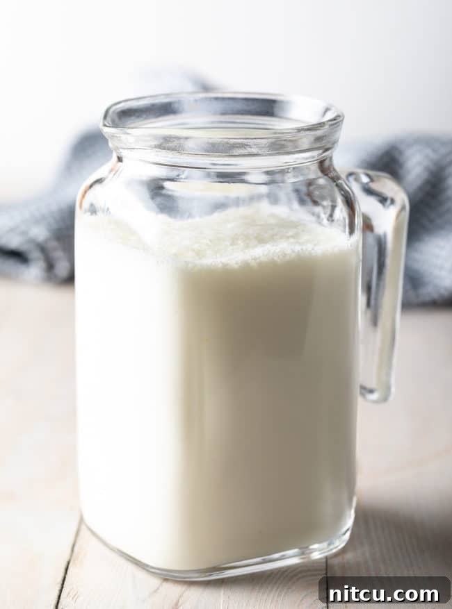 A charming glass pitcher filled with freshly made homemade buttermilk, ready for use.