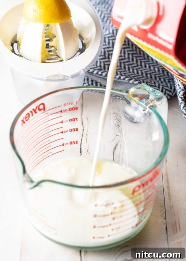 Pouring fresh milk into a glass measuring cup, preparing to make buttermilk.