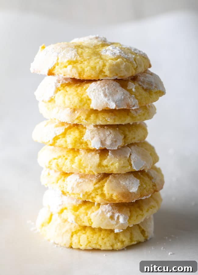 A beautifully arranged tower of soft, cake-like Lemon Crinkle Cookies, showcasing their delightful texture.