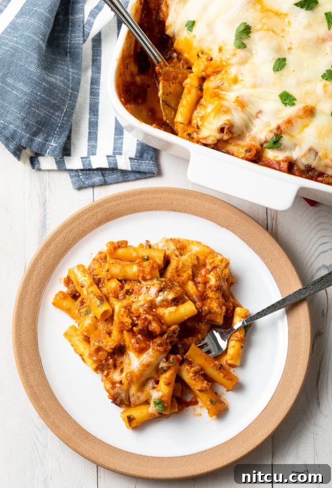 serving of baked ziti with Italian sausage on a white plate