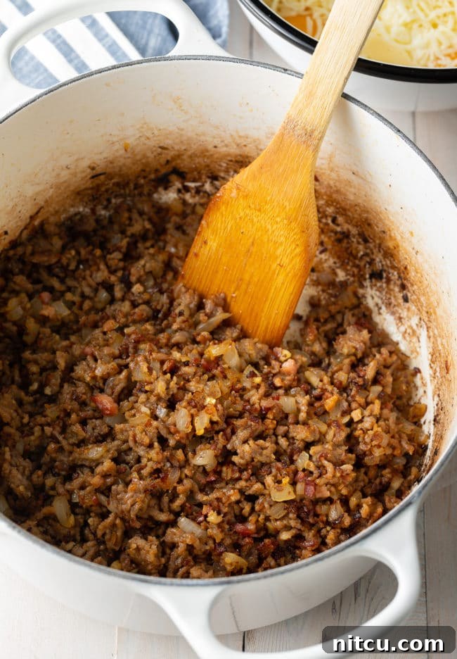 Italian sausage cooking in a pan for baked ziti recipe