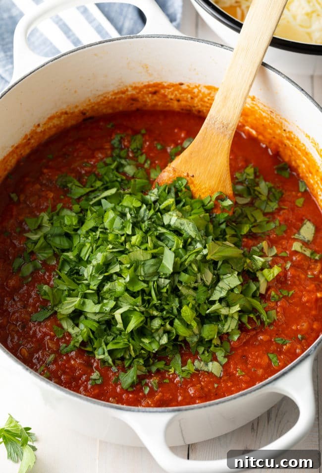 meat sauce with sausage simmering in a pot for baked ziti recipe