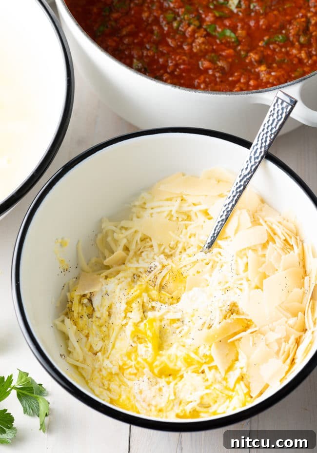 Ricotta mixture in a bowl, ready to be layered into baked ziti recipe