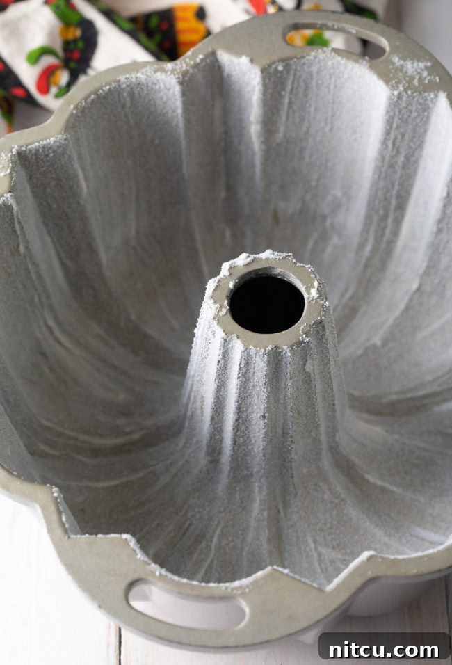 Close-up of a well-greased and floured bundt pan, ready for the pound cake batter, ensuring an easy release and a beautiful shape.