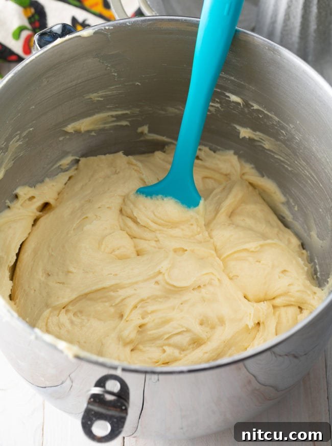 Ingredients for cream cheese pound cake laid out, including softened butter, cream cheese, eggs, and vanilla extract.